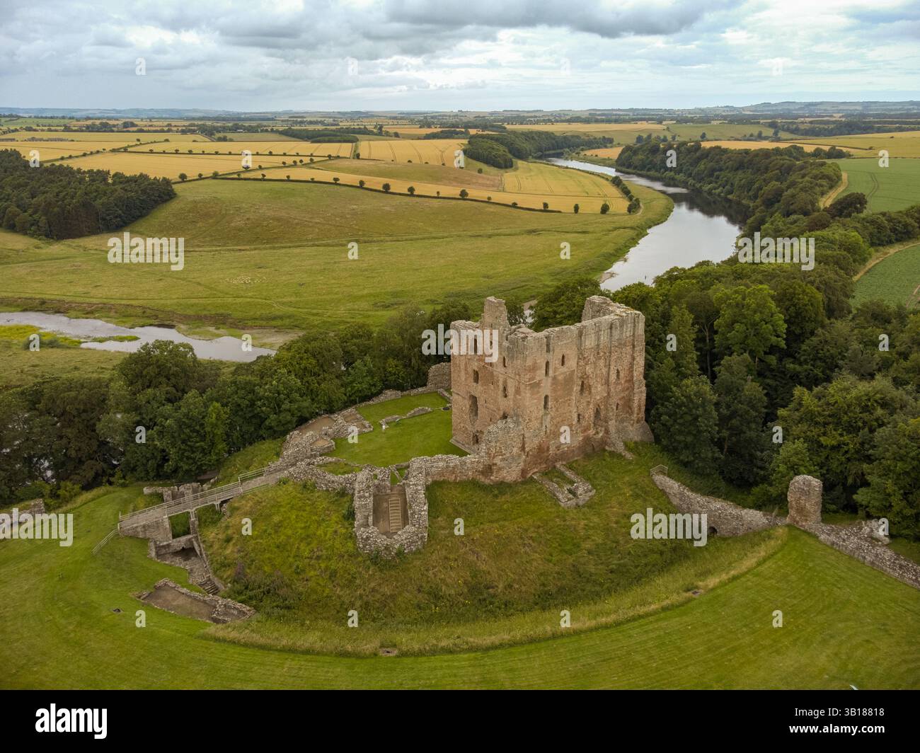 Photo aérienne du château de Norham sur les rives de la rivière Tweed dans le Northumberland, Angleterre. Banque D'Images