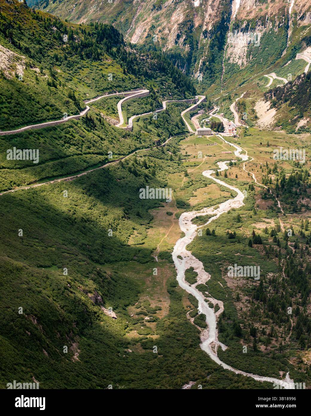 Vue panoramique sur le col de Furka, Suisse, avec route de montagne sinueuse à travers les Alpes suisses sous un ciel d'été clair. Banque D'Images