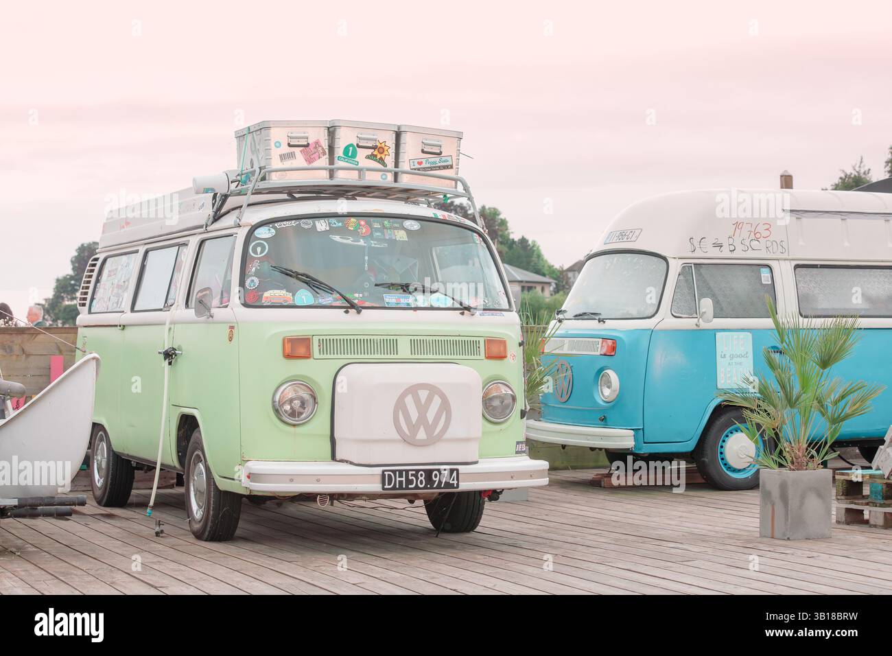 2 Vintage Volkswagen California camping-car garé près d'un littoral pittoresque, évoquant la liberté, les voyages estivaux et la culture du surf. Banque D'Images