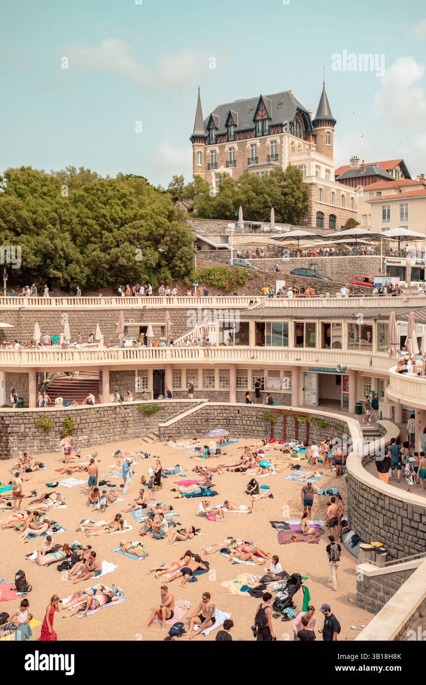 Plage du Port Vieux à Biarritz, pays Basque, France, avec des gens se relaxant sur la plage de sable et nageant dans les eaux calmes de la crique abritée Banque D'Images
