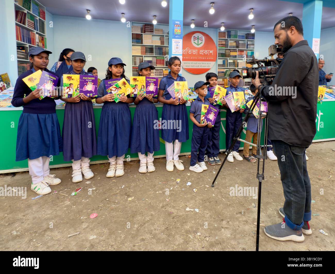 Un journaliste bangladais filme des élèves bangladais avec des livres et la foire du livre de Dhaka, au Bangladesh Banque D'Images