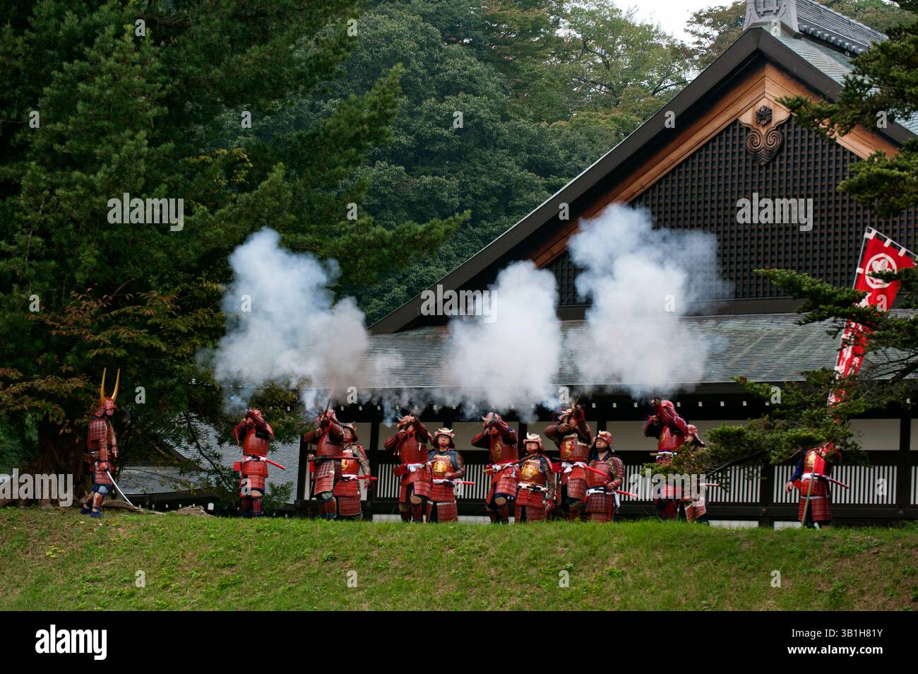 Groupe de guerriers samouraïs du clan II en costume tirant des mousquets vintage menés par un commandant avec une épée lors d'une manifestation de festival à Hikone, au Japon. Banque D'Images