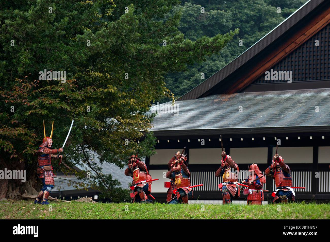 Groupe de guerriers samouraïs du clan II en costume tirant des mousquets vintage menés par un commandant avec une épée lors d'une manifestation de festival à Hikone, au Japon. Banque D'Images
