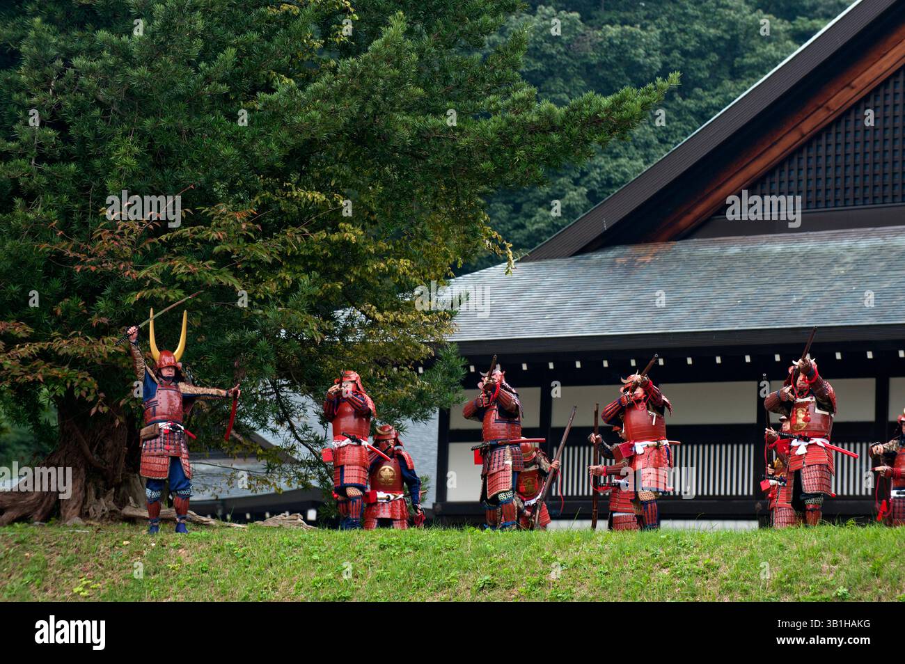 Groupe de guerriers samouraïs du clan II en costume tirant des mousquets vintage menés par un commandant avec une épée lors d'une manifestation de festival à Hikone, au Japon. Banque D'Images