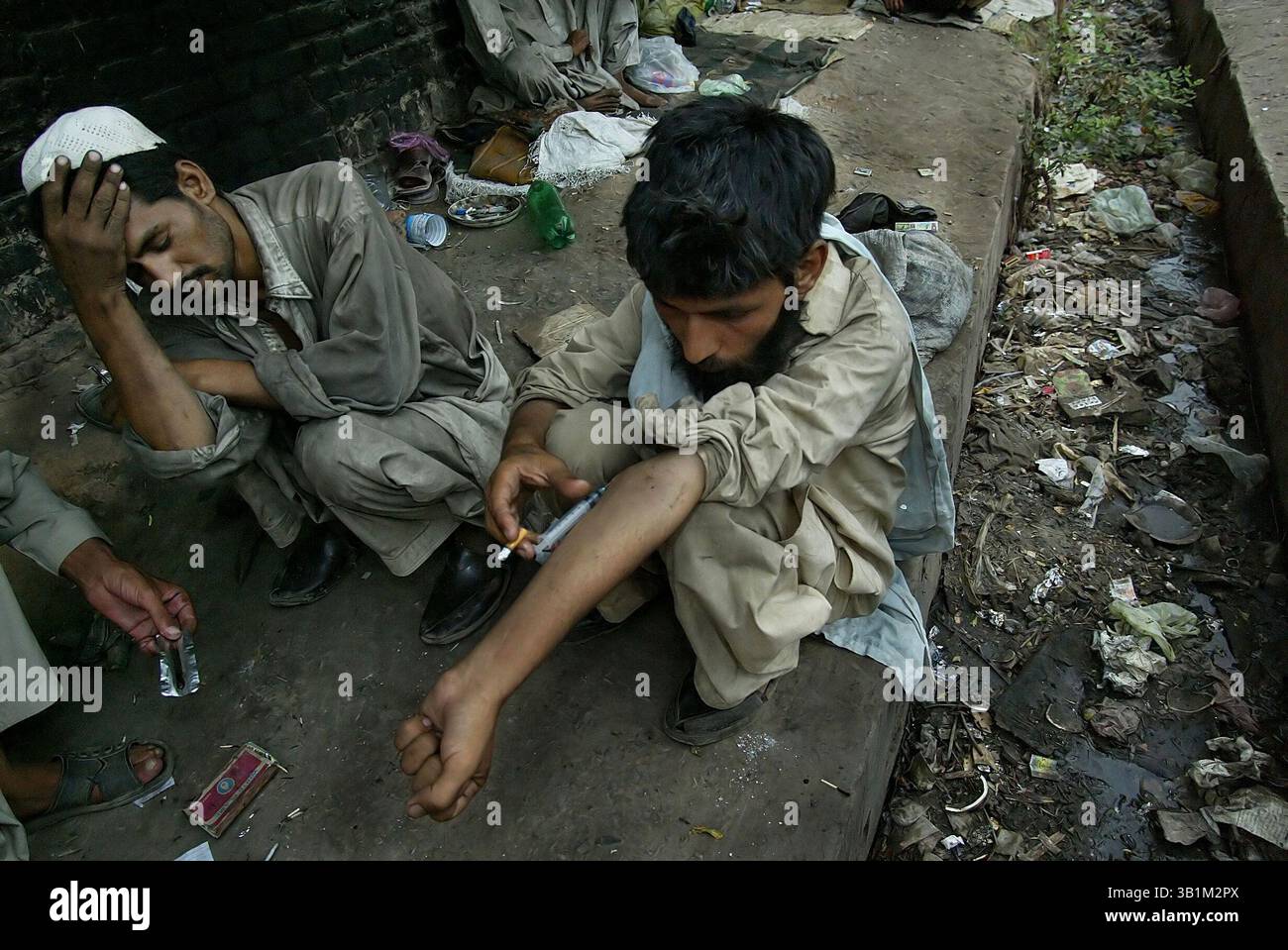 01 juin 2006 - Peshawar, PFNL, Pakistan - dans une zone entourée de saleté, un homme tire dessus. Des milliers d'héroïnomanes vivent dans les égouts sous les ponts de l'ouest du Pakistan. La plupart d'entre eux volent pour payer des médicaments, qui sont bon marché et facilement accessibles. En raison de leur dépendance aux drogues et de leurs conditions de vie déplorables, de nombreux consommateurs meurent jeunes. Le nombre de centres de réadaptation réussis est proche de zéro. La date est approximative. (Crédit image : © ton Koene/ZUMApress.com) Banque D'Images