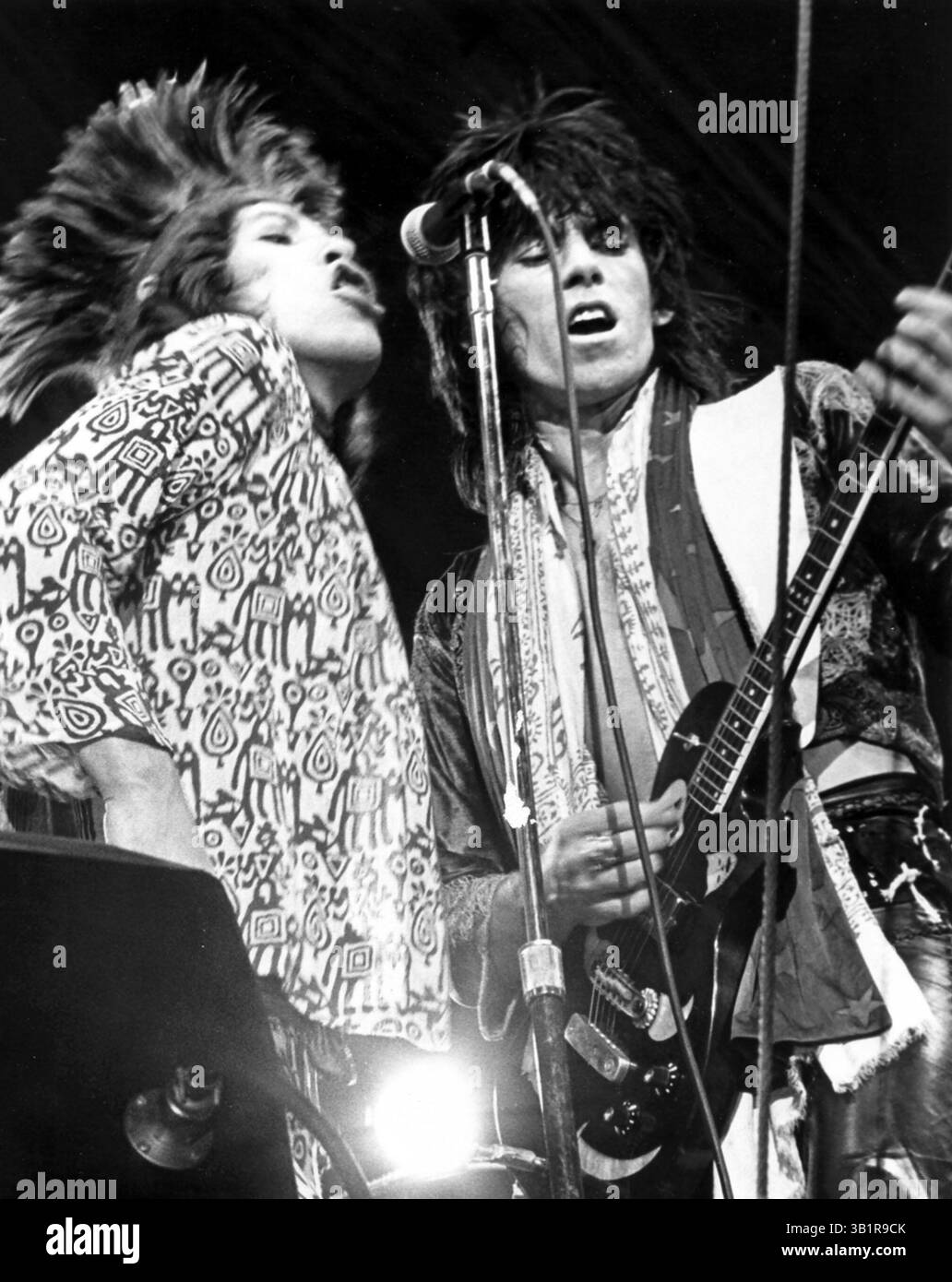 4 juillet 1975 - Memphis, TN, États-Unis - les Rolling Stones au Memorial Stadium (maintenant Liberty Bowl ) à Memphis le 4 juillet 1975. Mick Jagger (à gauche) Keith Richards sont photographiés. L'événement d'une journée comprenait des performances du Charles Daniels Band, du Meters et de la légende du blues Furry Lewis. ''Mick Jagger, vêtu d'un body à motifs rouge et blanc et d'une cape violette, a sombré légèrement sous un parasol'', a écrit Walter Dawson. ''il y avait eu une certaine inquiétude dans le camp des Stones... qu'ils pourraient être arrêtés pour obscénité s'ils utilisaient leur ballon en forme de phallique et effectuaient un petit nombre qui va sous l'alia Banque D'Images