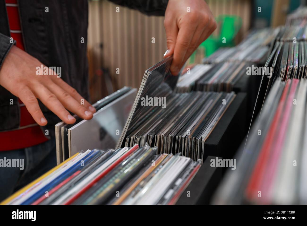 Homme qui choisit des disques vinyles en magasin, gros plan Banque D'Images