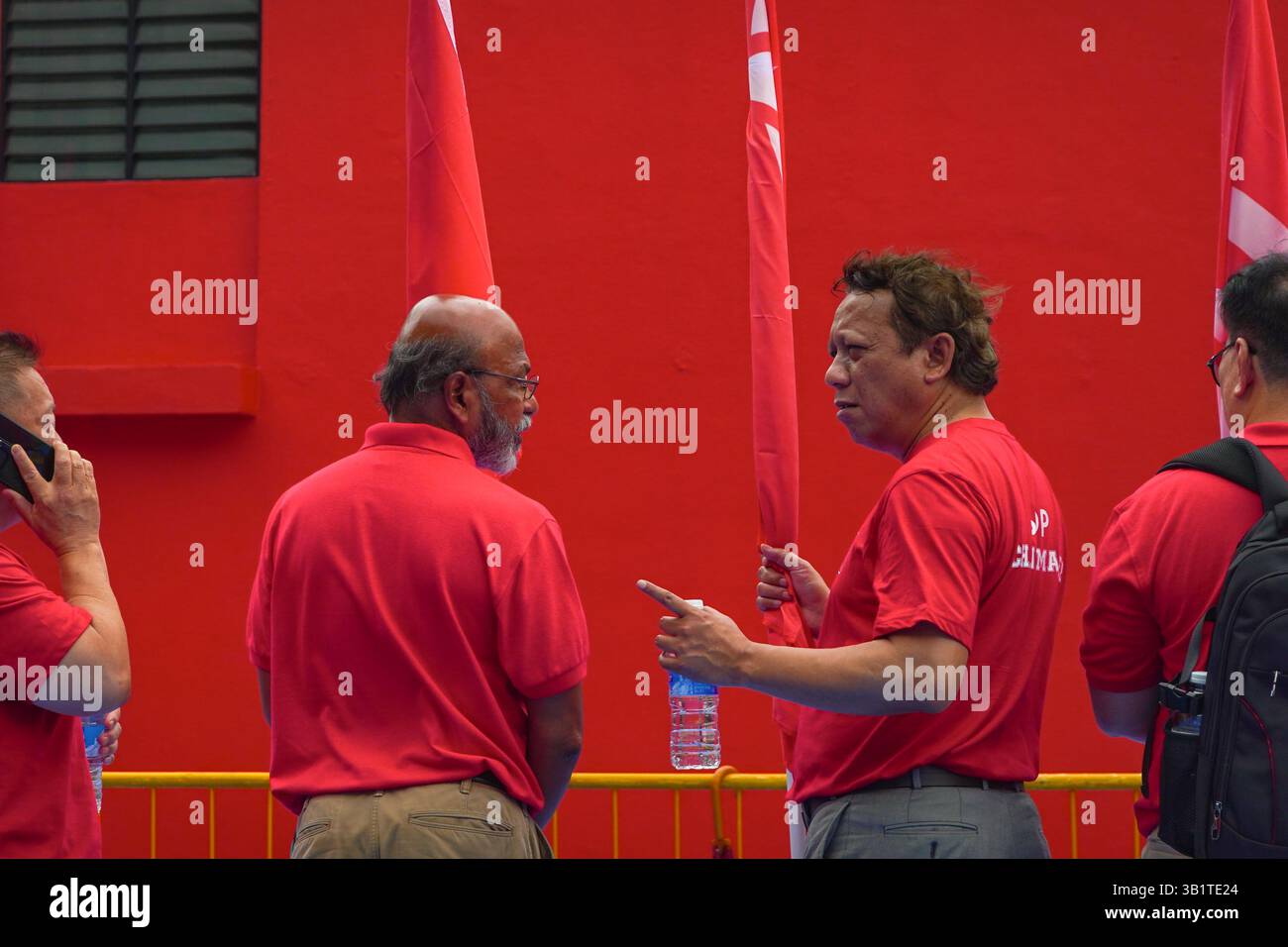 Singapour 2025 avr23 - jour de la nomination aux élections générales. Les partisans du SDP discutent sur le terrain à l'école de Chongfu en attendant le retour Banque D'Images