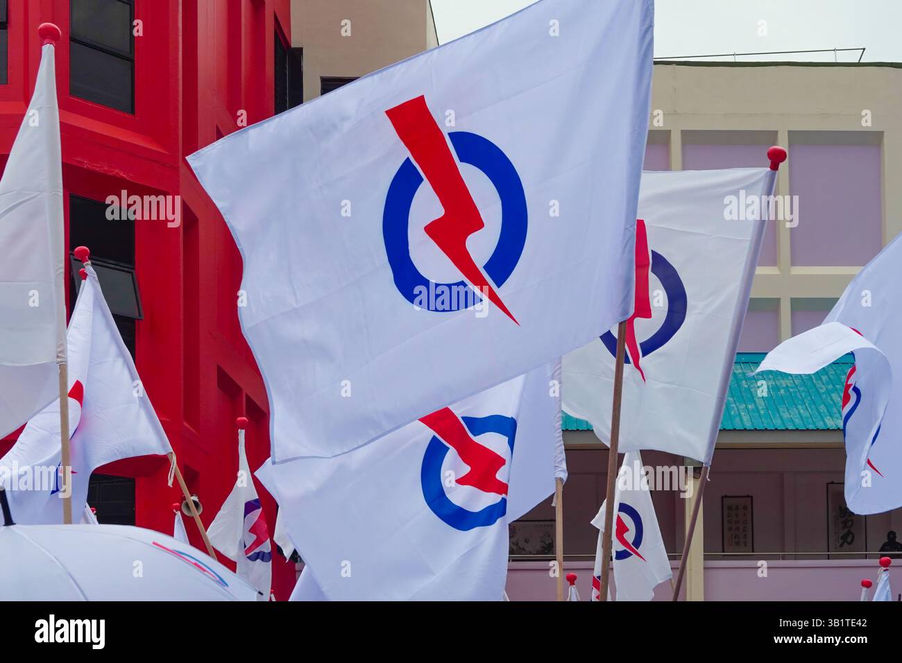 Singapour 2025 avr 23 - drapeaux du parti People's action Party (PAP) agitant sur fond de centre de nomination de l'école de Chongfu le jour de la nomination pendant si Banque D'Images