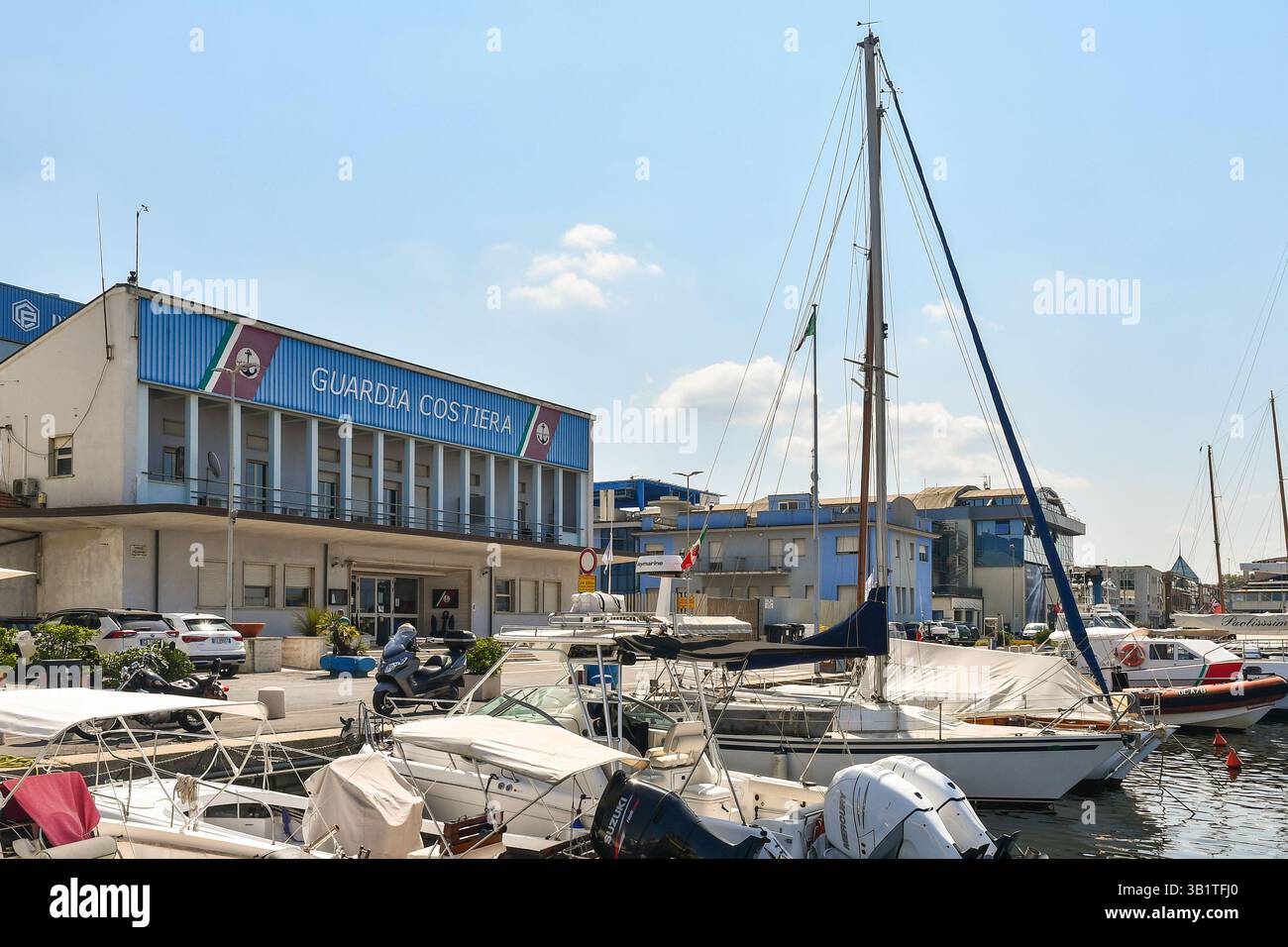 Le siège de la Garde côtière surplombant le quai Darsena Europa, avec des chantiers navals en arrière-plan en été, Viareggio (Lucques), Toscane, Italie Banque D'Images
