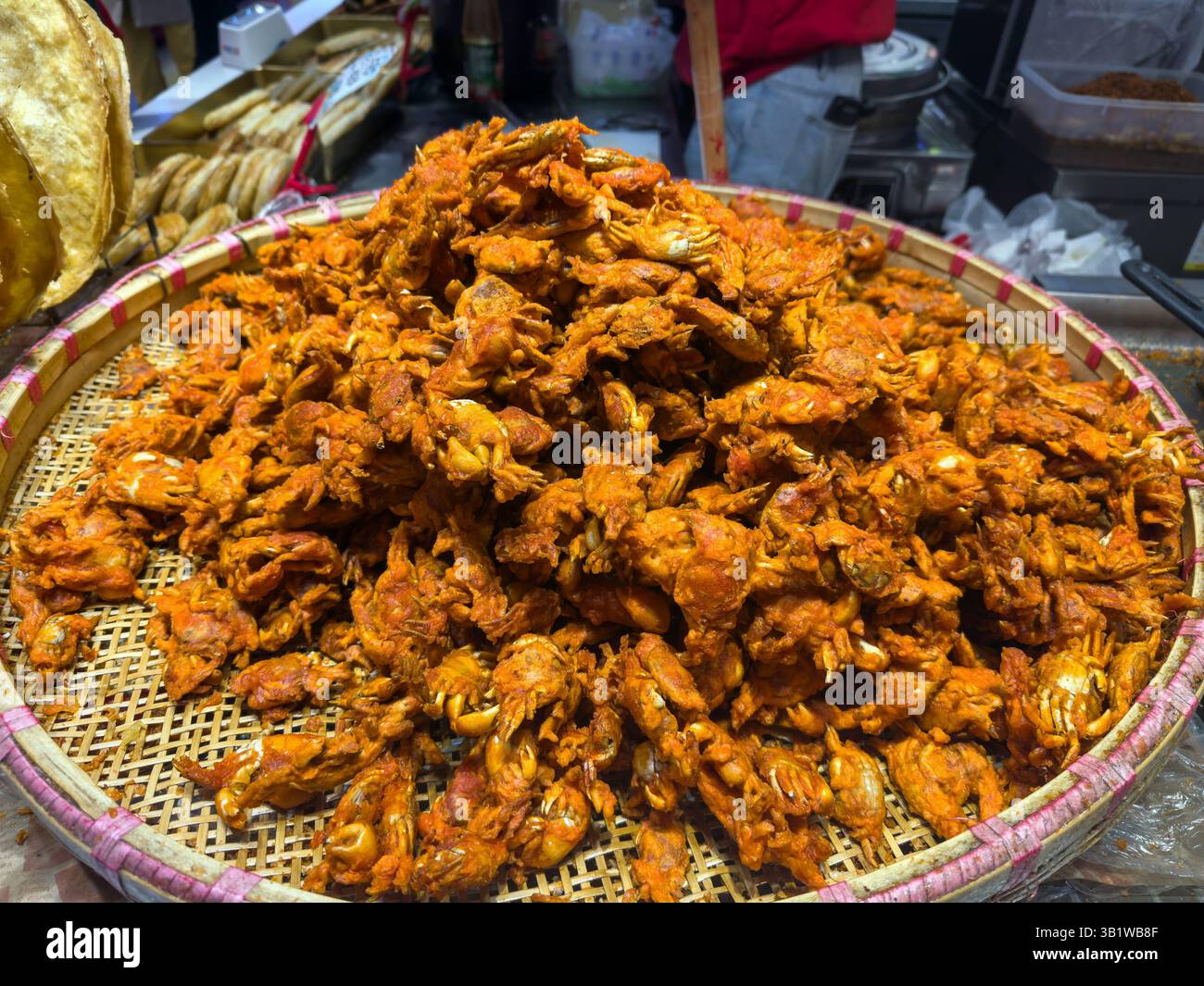 Cuisine de rue chinoise. Crabes croustillants frits dans un plateau en bambou vue rapprochée. Banque D'Images