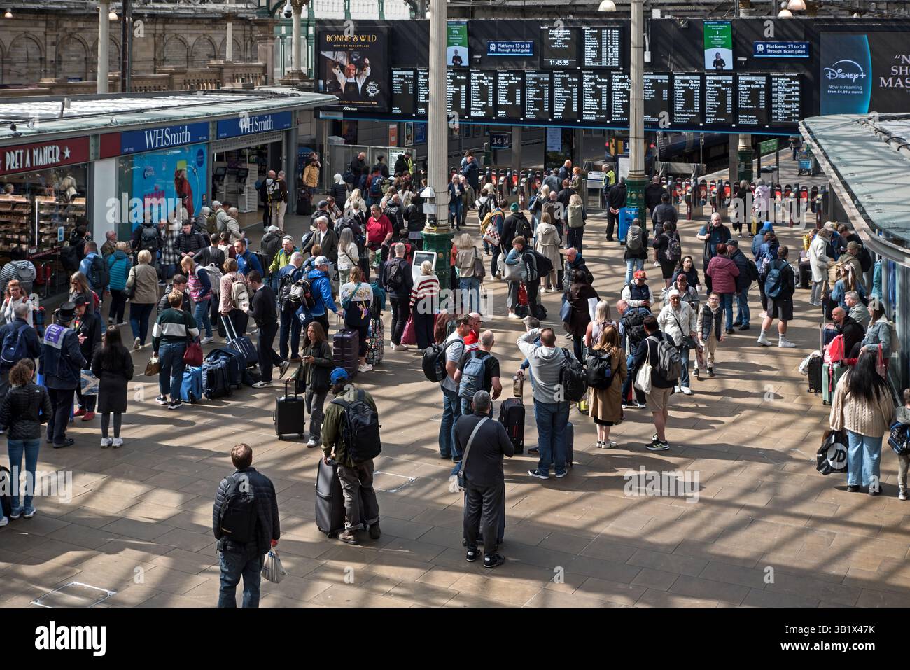 Voyageurs ferroviaires attendant dans le hall de la gare de Waverley, Édimbourg, Écosse, Royaume-Uni. Banque D'Images