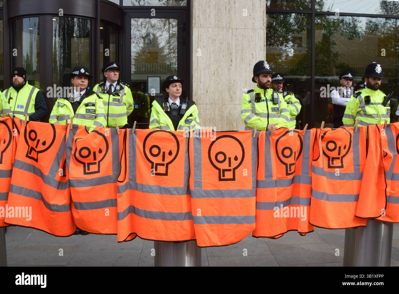 Londres, Royaume-Uni. 26 avril 2025. Londres, Royaume-Uni. 26 avril 2025. Londres, Royaume-Uni. 26 avril 2025. Les militants de Just Stop Oil pendent leurs gilets orange alors que les policiers gardent l'entrée devant le siège de Shell lors de leur manifestation finale. Le groupe climatique a récemment annoncé qu’il cesserait ses actions de protestation. Crédit : SOPA images Limited/Alamy Live News crédit : SOPA images Limited/Alamy Live News crédit : SOPA images Limited/Alamy Live News Banque D'Images