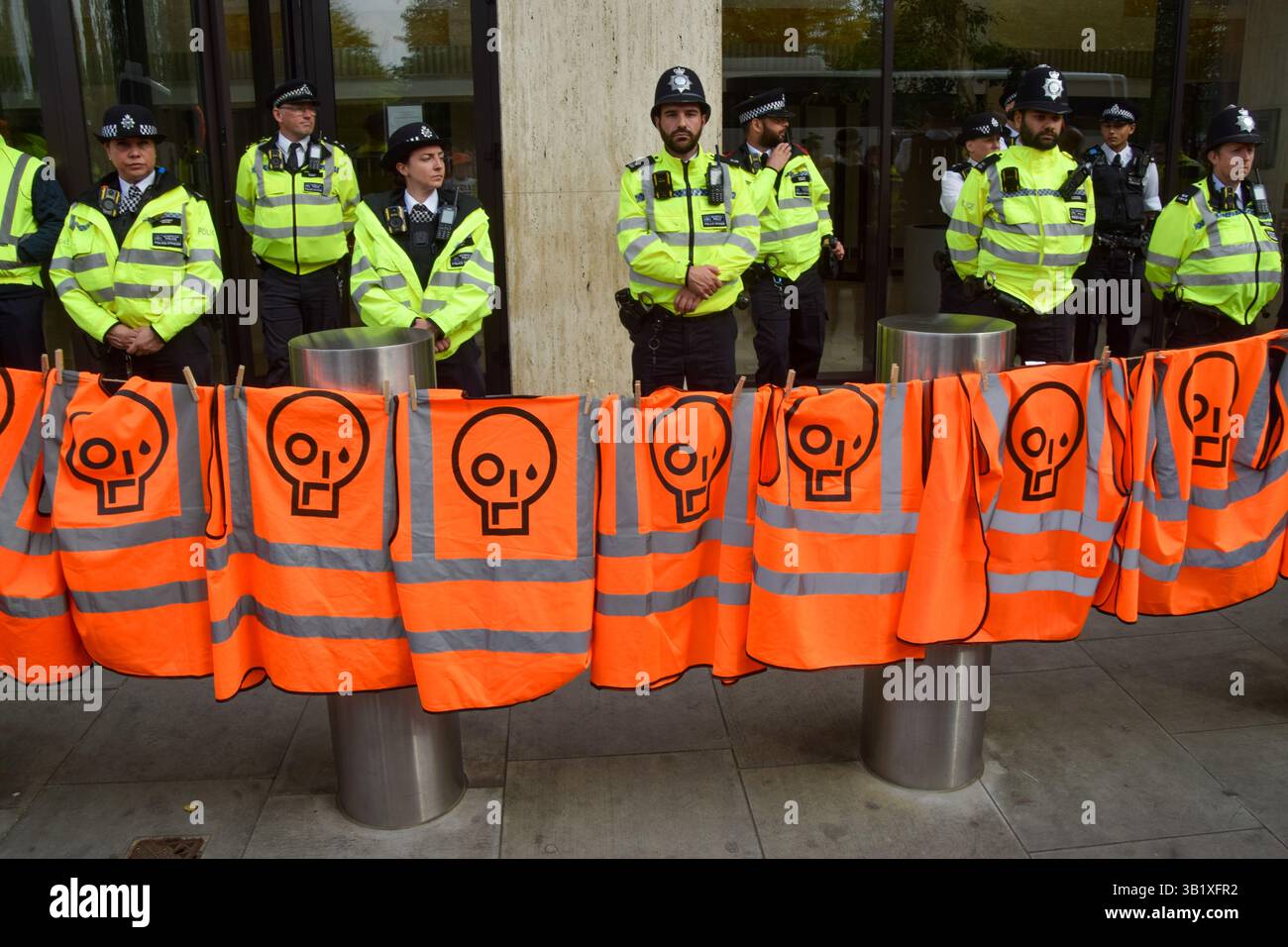 Londres, Royaume-Uni. 26 avril 2025. Londres, Royaume-Uni. 26 avril 2025. Londres, Royaume-Uni. 26 avril 2025. Les militants de Just Stop Oil pendent leurs gilets orange alors que les policiers gardent l'entrée devant le siège de Shell lors de leur manifestation finale. Le groupe climatique a récemment annoncé qu’il cesserait ses actions de protestation. Crédit : SOPA images Limited/Alamy Live News crédit : SOPA images Limited/Alamy Live News crédit : SOPA images Limited/Alamy Live News Banque D'Images