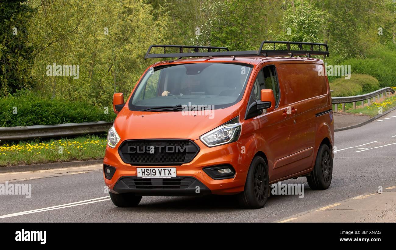Milton Keynes, UK - 26 avril 2025 : 2019 orange Ford transit van personnalisé conduite sur une route britannique Banque D'Images