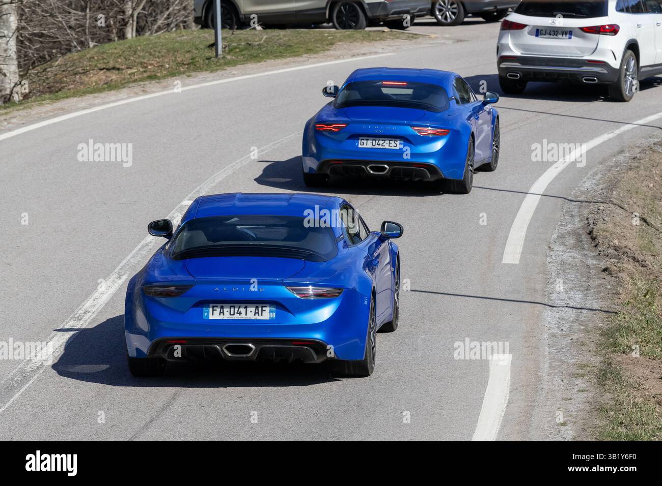 Le Valtin, France - vue sur deux Alpine bleue A110 conduisant sur une route. Banque D'Images