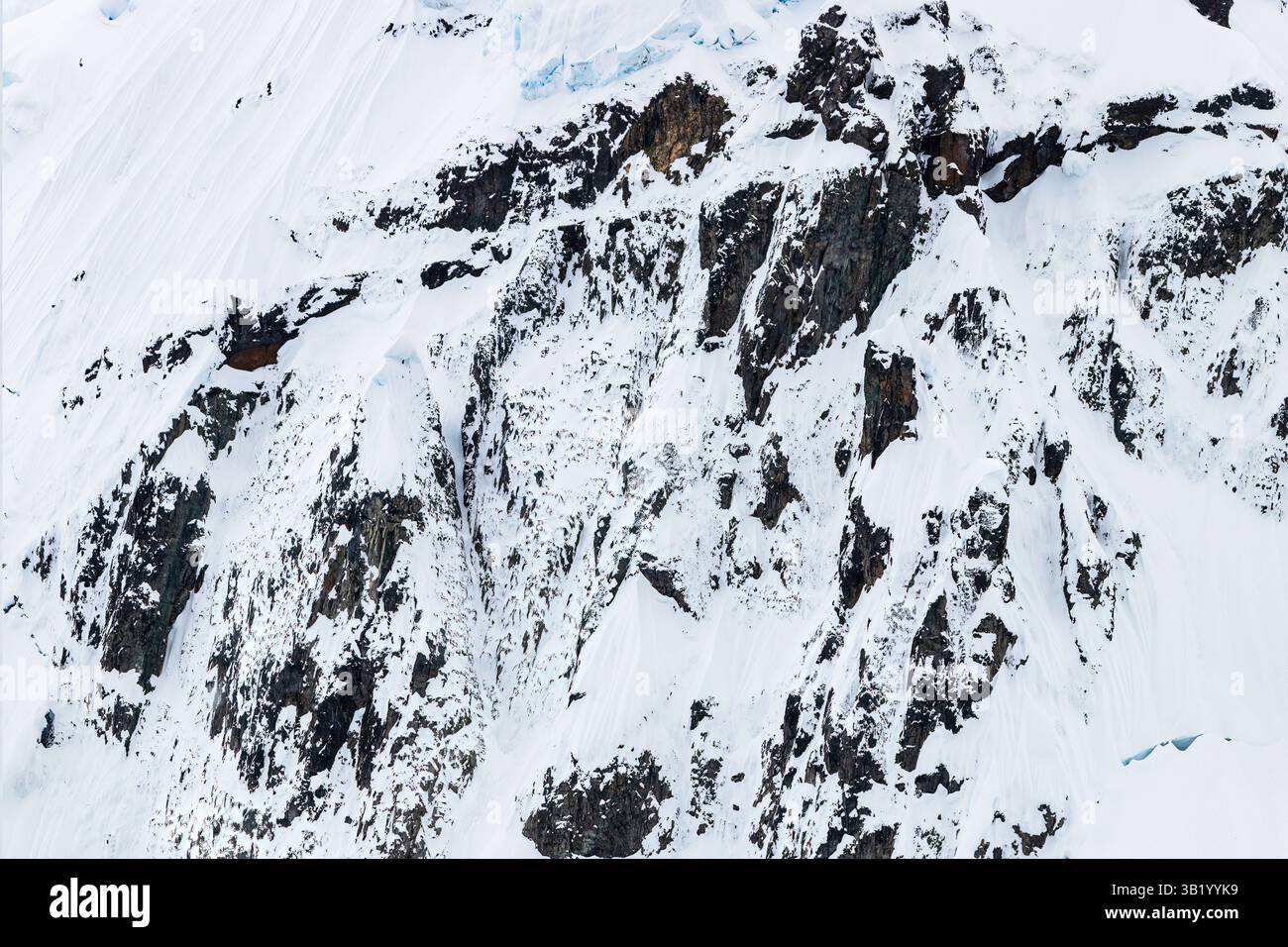 Falaise recouverte de neige rocheuse sur les rives de la péninsule Antarctique. Banque D'Images