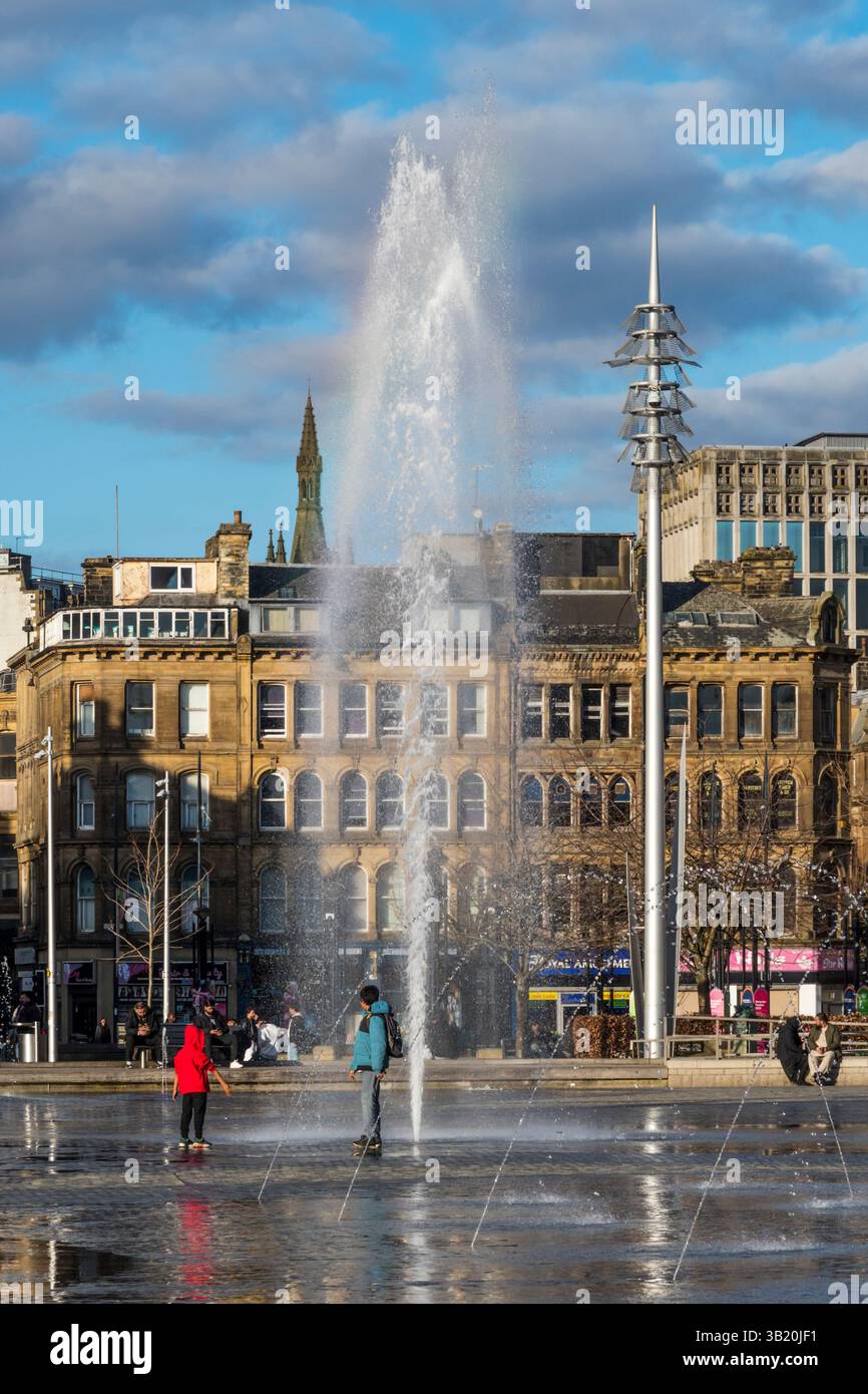 Les enfants apprécient les fontaines de Centenary Square dans le centre de Bradford. Banque D'Images