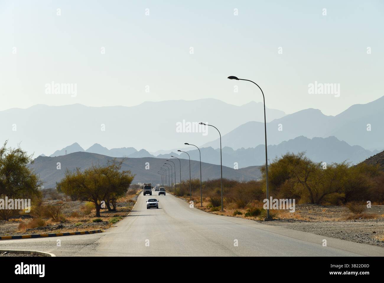 Nizwa, Sultanat d'Oman - 6 avril 2025 : route goudronnée et trafic routier à Oman, montagnes en arrière-plan. Péninsule arabique Banque D'Images