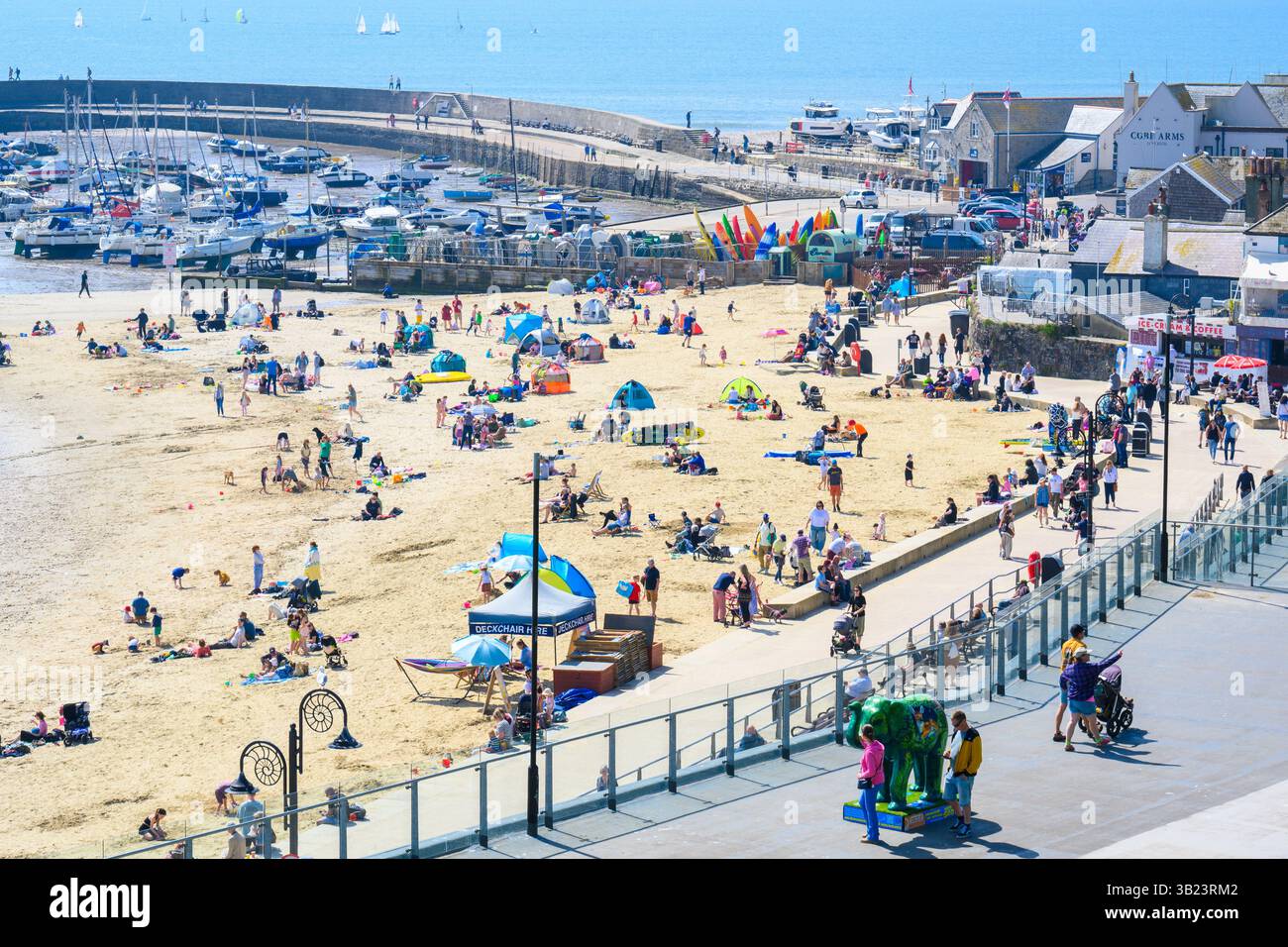 Lyme Regis, Dorset, Royaume-Uni. 27 avril 2025. Météo britannique : les voyageurs d'une journée et les habitants affluent à la plage de la pittoresque station balnéaire de Lyme Regis pour se prélasser sous un soleil brûlant le dimanche. Des conditions chaudes et ensoleillées sont prévues toute la semaine avec des températures fixées pour monter en flèche vers le week-end, lorsque le Royaume-Uni est susceptible de voir le jour le plus chaud de l'année jusqu'à présent. Crédit : Celia McMahon/Alamy Live News Banque D'Images