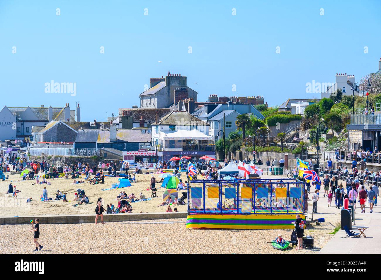 Lyme Regis, Dorset, Royaume-Uni. 27 avril 2025. Météo britannique : les voyageurs d'une journée et les habitants affluent à la plage de la pittoresque station balnéaire de Lyme Regis pour se prélasser sous un soleil brûlant le dimanche. Des conditions chaudes et ensoleillées sont prévues toute la semaine avec des températures fixées pour monter en flèche vers le week-end, lorsque le Royaume-Uni est susceptible de voir le jour le plus chaud de l'année jusqu'à présent. Crédit : Celia McMahon/Alamy Live News Banque D'Images