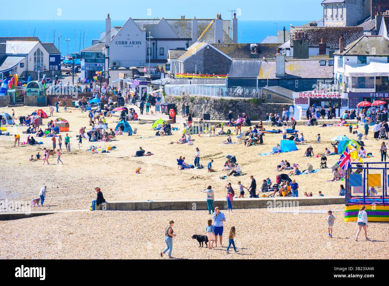 Lyme Regis, Dorset, Royaume-Uni. 27 avril 2025. Météo britannique : les voyageurs d'une journée et les habitants affluent à la plage de la pittoresque station balnéaire de Lyme Regis pour se prélasser sous un soleil brûlant le dimanche. Des conditions chaudes et ensoleillées sont prévues toute la semaine avec des températures fixées pour monter en flèche vers le week-end, lorsque le Royaume-Uni est susceptible de voir le jour le plus chaud de l'année jusqu'à présent. Crédit : Celia McMahon/Alamy Live News Banque D'Images
