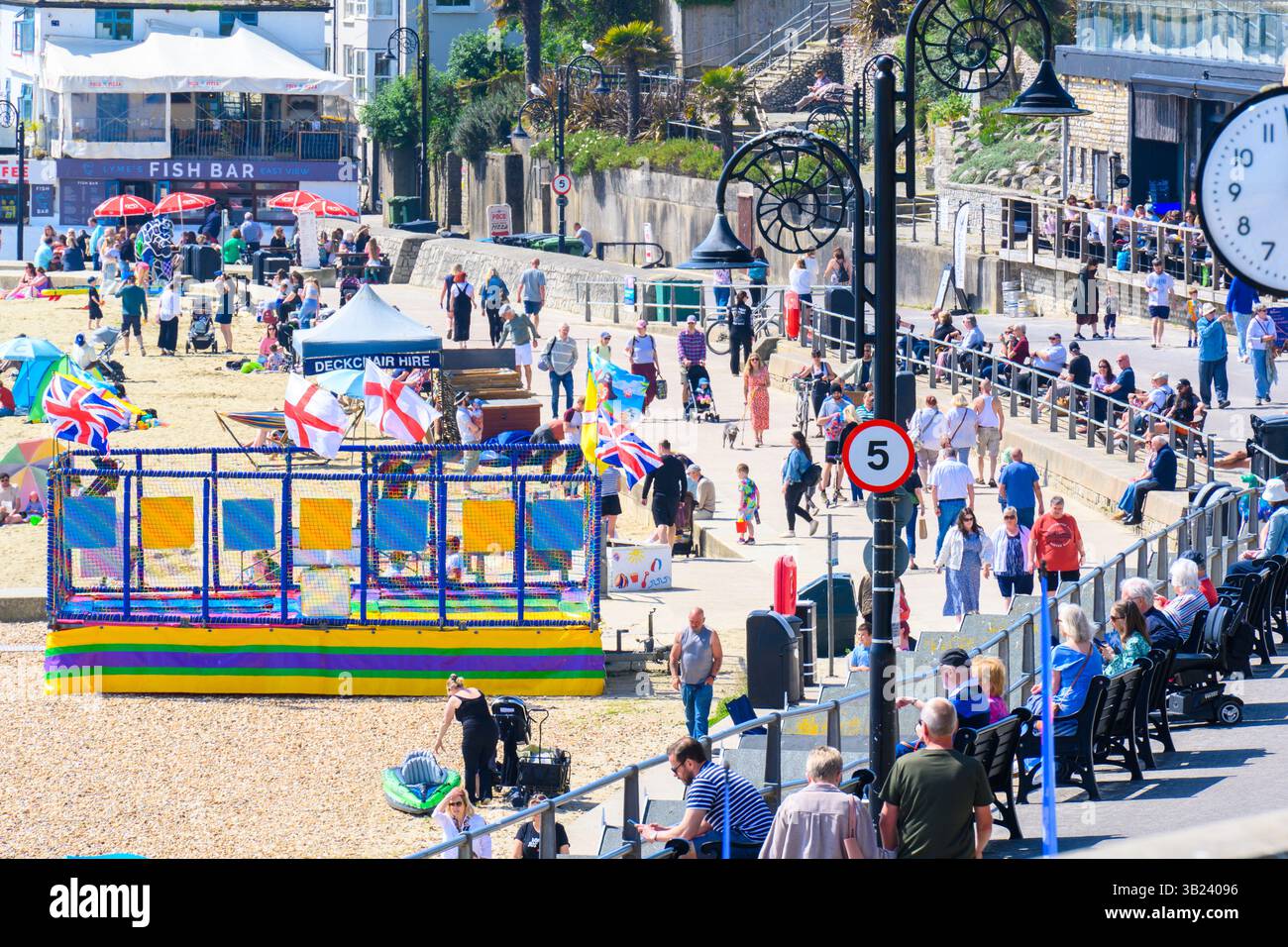Lyme Regis, Dorset, Royaume-Uni. 27 avril 2025. Météo britannique : les voyageurs d'une journée et les habitants affluent à la plage de la pittoresque station balnéaire de Lyme Regis pour se prélasser sous un soleil brûlant le dimanche. Des conditions chaudes et ensoleillées sont prévues toute la semaine avec des températures fixées pour monter en flèche vers le week-end, lorsque le Royaume-Uni est susceptible de voir le jour le plus chaud de l'année jusqu'à présent. Crédit : Celia McMahon/Alamy Live News Banque D'Images
