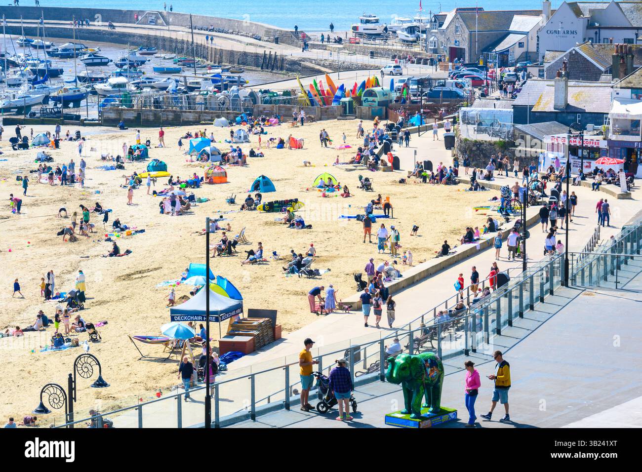 Lyme Regis, Dorset, Royaume-Uni. 27 avril 2025. Météo britannique : les voyageurs d'une journée et les habitants affluent à la plage de la pittoresque station balnéaire de Lyme Regis pour se prélasser sous un soleil brûlant le dimanche. Des conditions chaudes et ensoleillées sont prévues toute la semaine avec des températures fixées pour monter en flèche vers le week-end, lorsque le Royaume-Uni est susceptible de voir le jour le plus chaud de l'année jusqu'à présent. Crédit : Celia McMahon/Alamy Live News Banque D'Images