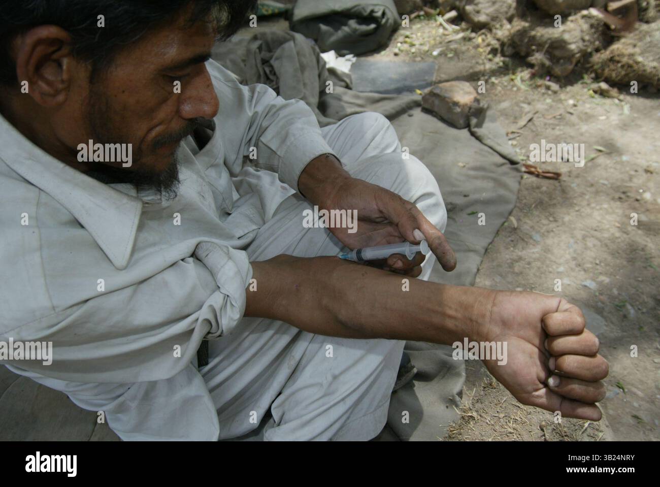 09 février 2009 - Peshawar, Pakistan - Un homme tire sur l'héroïne avec une aiguille de seringue dans une ruelle. Des milliers d'héroïnomanes vivent sous les ponts de peshawar, dans l'ouest DU PAKISTAN. La plupart d'entre eux volent pour acheter de la drogue qui est très bon marché et disponible pour 1 euro par injection en afghanistan. (Crédit image : © ton Koene/ZUMAPRESS.com) Banque D'Images