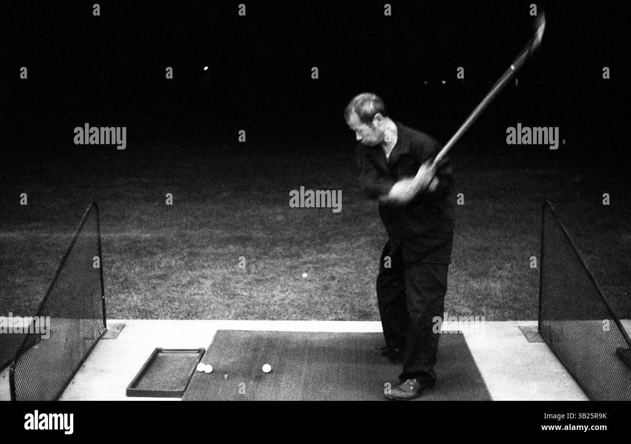 Travailleur essayant le golf après le travail au Beijing Golf course, années 2010 - swing de golf non professionnel par travailleur au Beijing Golf course, après les heures de travail, Beijing, Chine Banque D'Images