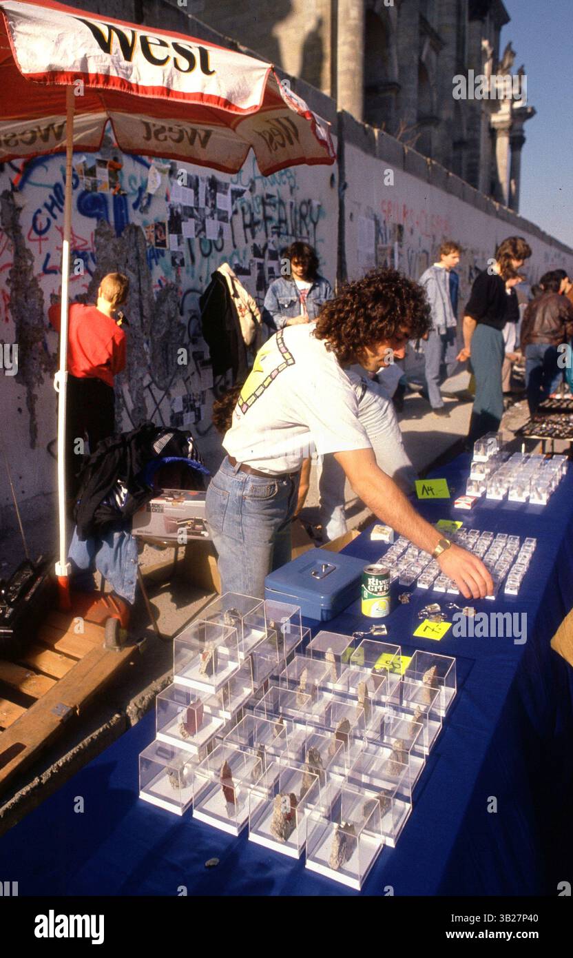 05 février 1990 - Berlin, Allemagne - Un homme vend des souvenirs du mur de Berlin, devant le Reichstag, à Berlin, Allemagne. Une section du mur de Berlin-Ouest a été démolie permettant aux gens de se promener dans Berlin-est. (Crédit image : © Deirdre Hamill/ZUMA Press) Banque D'Images