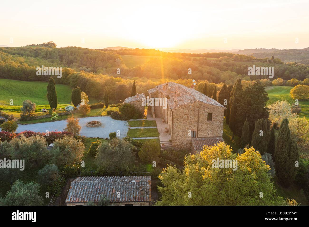 Ferme toscane au coucher du soleil, mettant en valeur l'architecture et le paysage italiens Banque D'Images