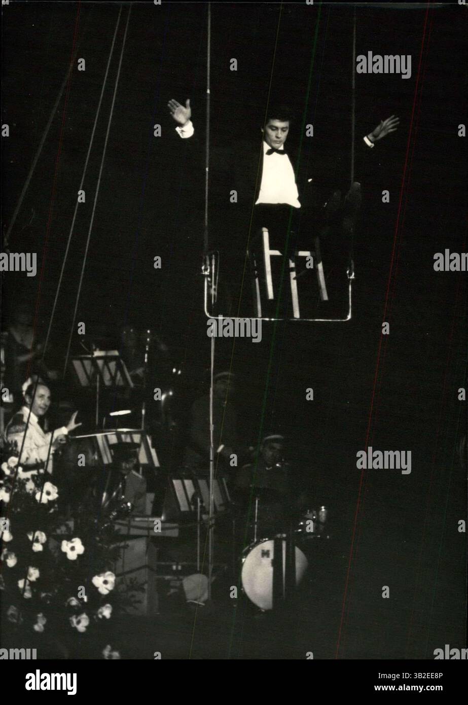31 mars 2012 - Gala des artistes français : le gala annuel des artistes français s'est tenu au cirque d'hiver à Paris hier soir - 38 stars célèbres ont participé à la performance. La photo montre le jeune acteur Alain Delon jouant le rôle d'acrobate sur une chaise sur un trapèze à io mètres au-dessus de l'échouement. (Crédit image : © Keystone Pictures USA/ZUMAPRESS.com) Banque D'Images