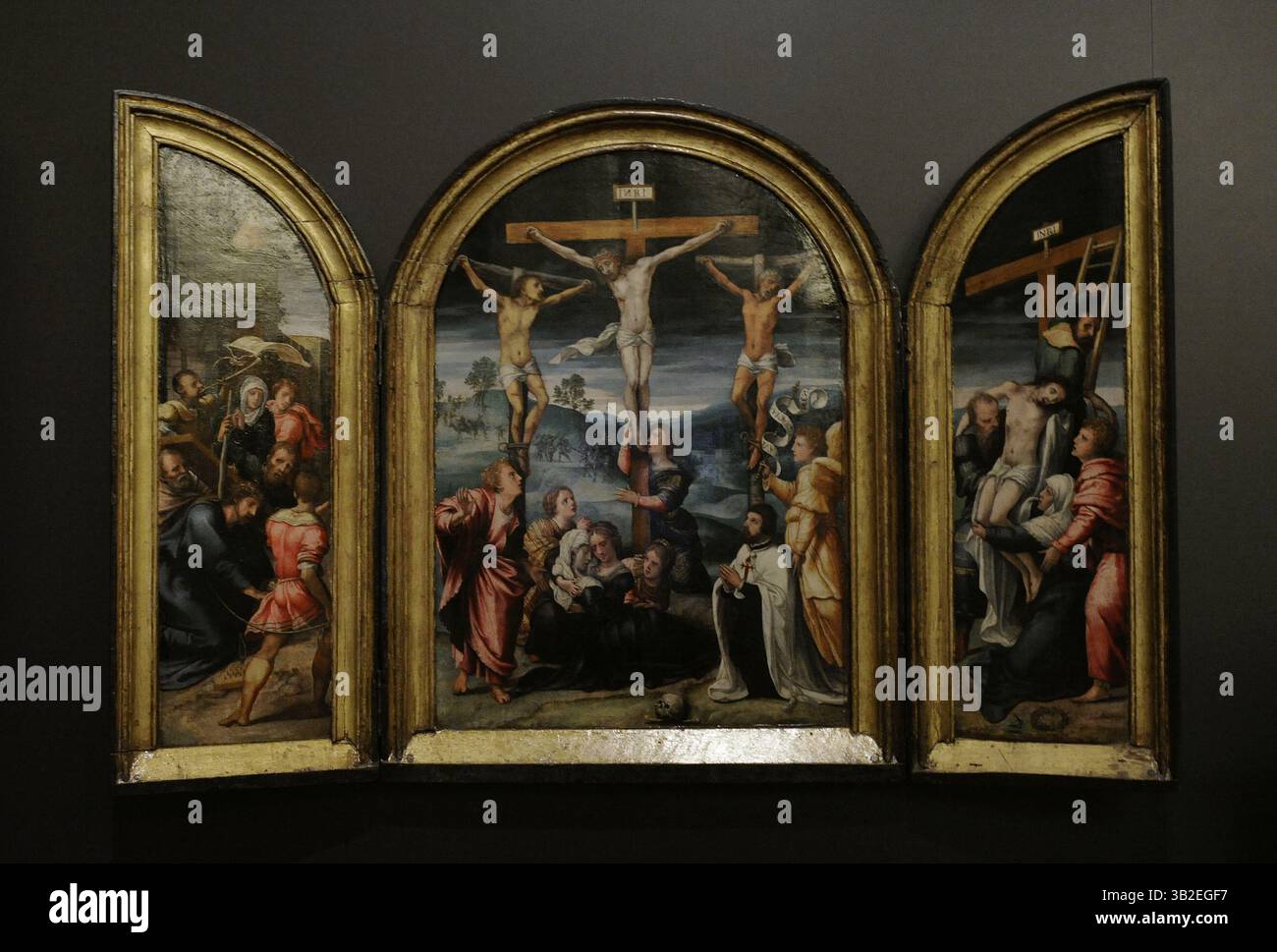 Passion Triptyque du Chevalier de l'ordre de Santiago. Les trois panneaux représentent des épisodes de la passion : une des trois chutes du Christ sur la route du Calvaire (à gauche), la Crucifixion (au centre) et la descente de la Croix (à droite). Le panneau central représente le donateur ou commissaire de l’œuvre, un chevalier agenouillé vêtu de l’habit de l’ordre de Santiago, présenté par l’archange Saint Gabriel. Peintre flamand anonyme du second tiers du XVIe siècle. Hauteur : 75 cm, largeur : 114,5 cm. Anvers, Belgique. Musée archéologique national. Madrid. Espagne. Banque D'Images