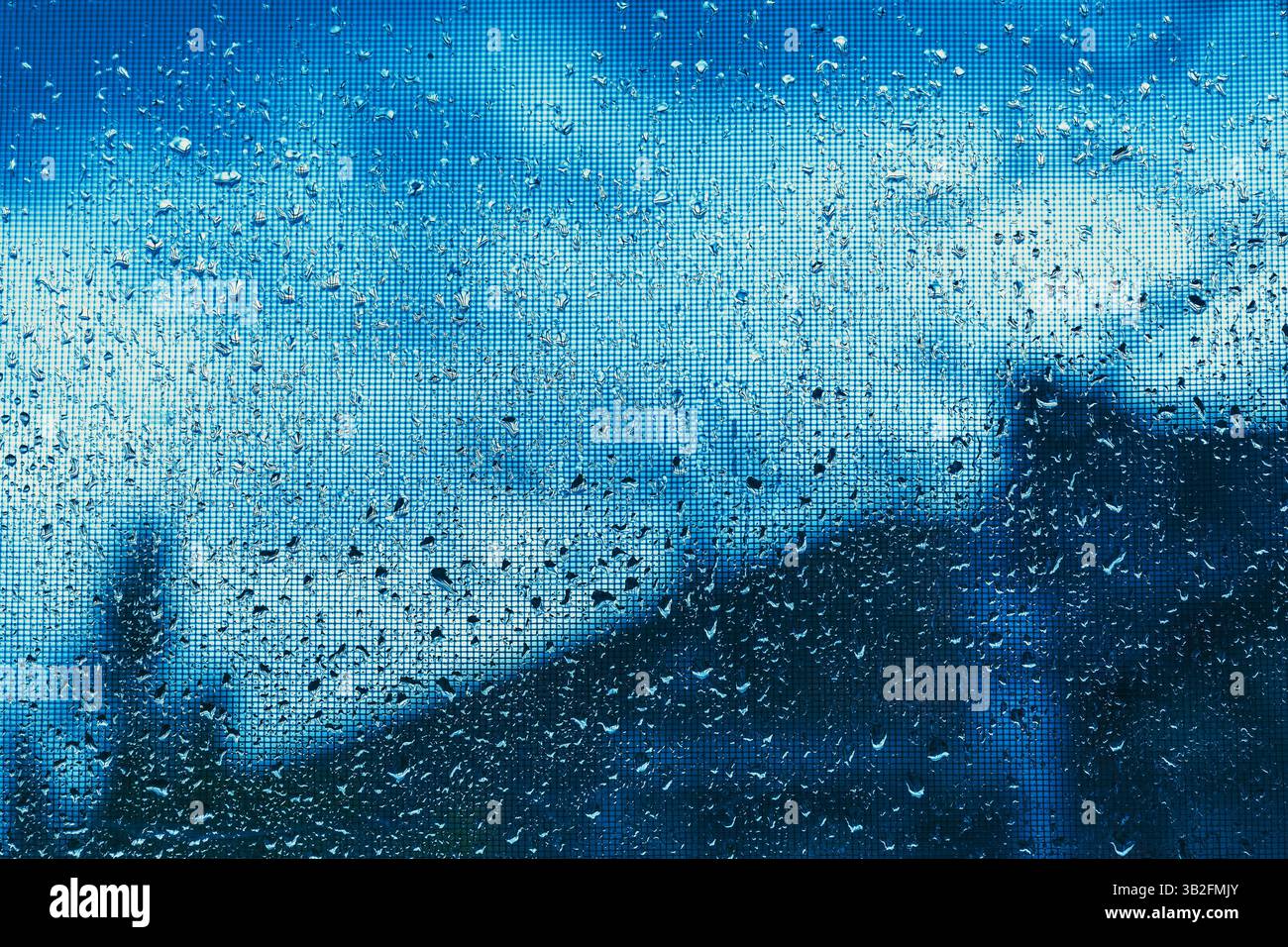 Gouttes de pluie sur moustiquaire de fenêtre, fond météo et climatique, mise au point sélective Banque D'Images