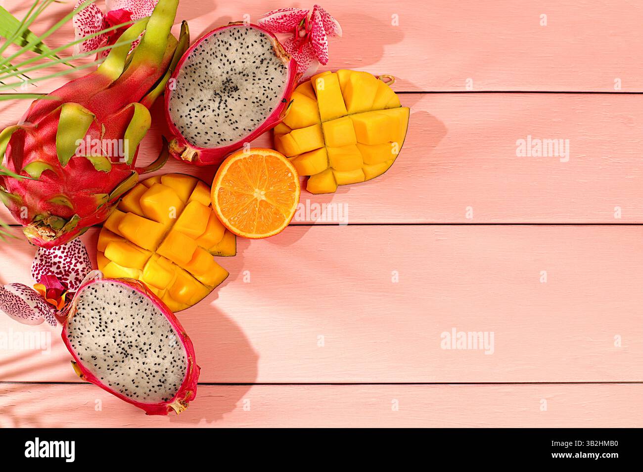 Nourriture saine végétalienne pour perdre du poids, carte publicitaire pour un magasin. Fruit du dragon, pitaya, mangue et oranges sur une table ensoleillée. Bannière d'été avec tropica Banque D'Images