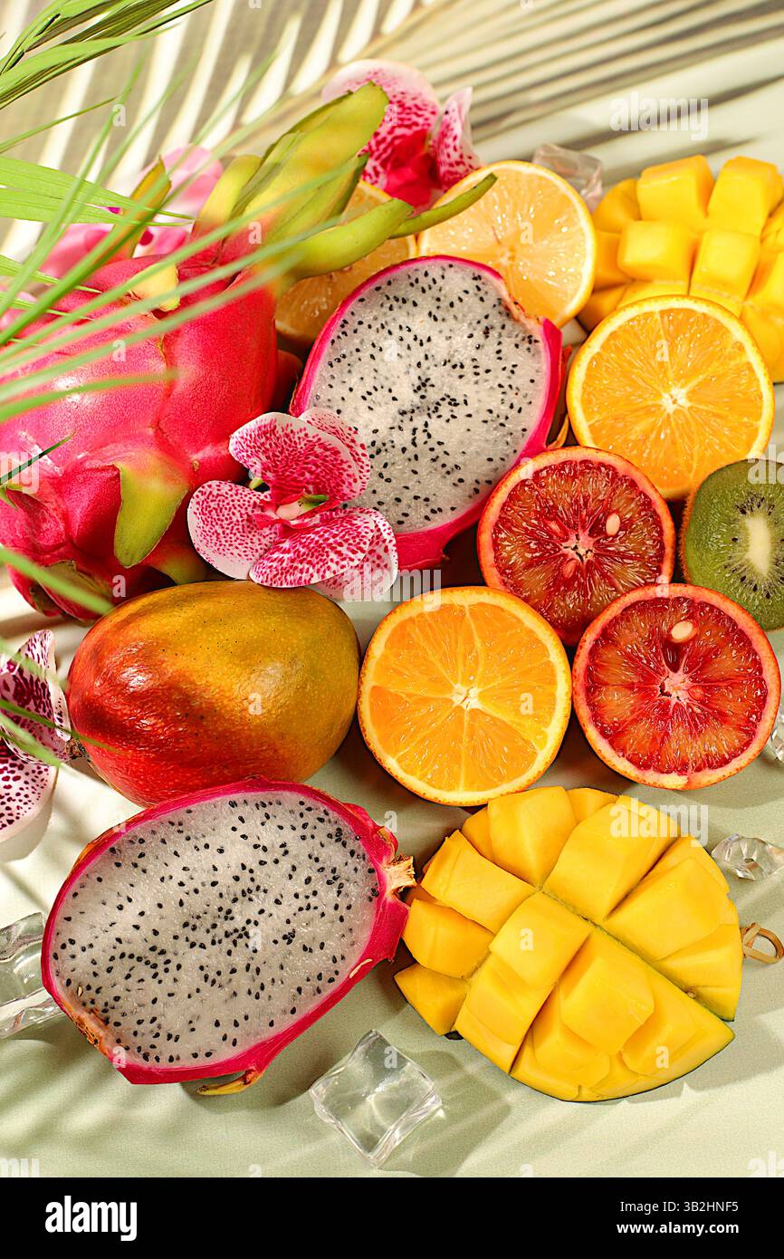 Nourriture saine végétalienne pour perdre du poids, carte publicitaire pour un magasin. Fruit du dragon, pitaya, mangue et oranges sur une table ensoleillée. Bannière d'été avec tropica Banque D'Images