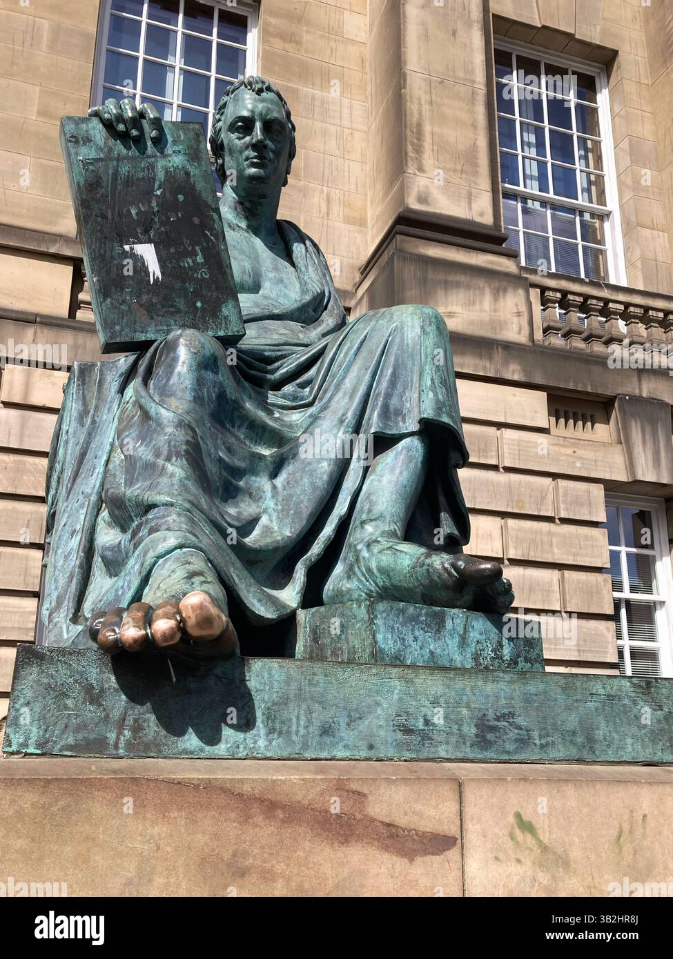 La statue de David Hume avec son orteil brillant après avoir été sans cesse frotté par les touristes pour bonne chance, Royal Mile, Édimbourg Écosse - Image de stock capturée avec un smartphone