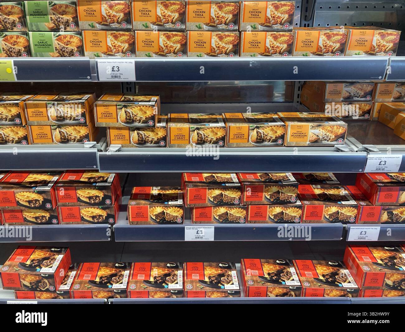 Choix de plats cuisinés individuels en vente chez Marks & Spencer dans une armoire réfrigérée, sélection de tartes : poulet, bœuf et bifteck, Royaume-Uni - Image de stock capturée avec un smartphone
