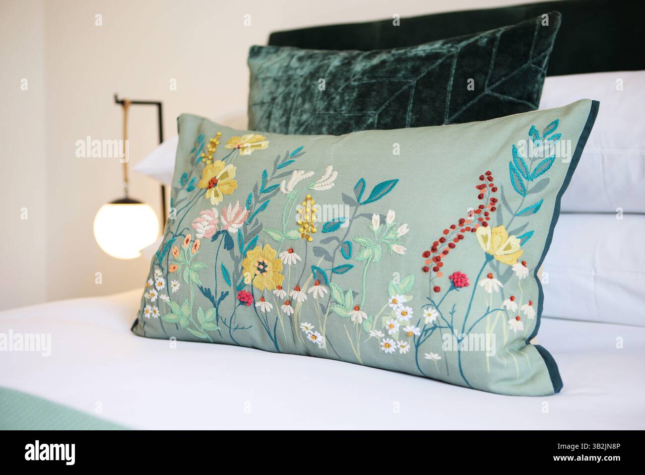 Maison, décoration et oreiller sur lit ou tapisserie fleurs dans l'appartement ou couture créative, décorations ou design d'intérieur. Coussin, floral et cosy Banque D'Images