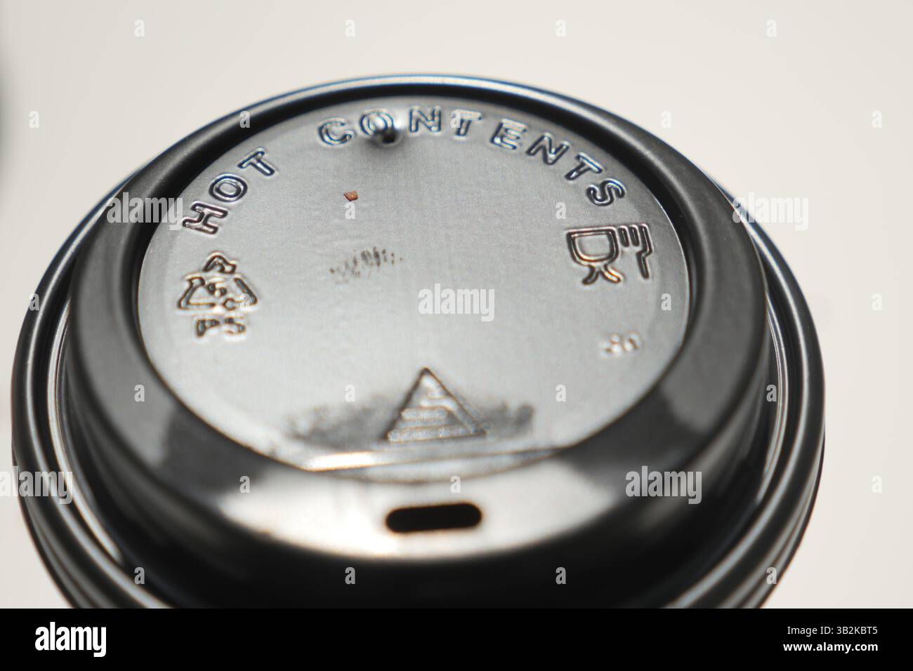 Couvercle d'un gobelet de boisson chaude avec symboles d'avertissement clairement affichés Banque D'Images