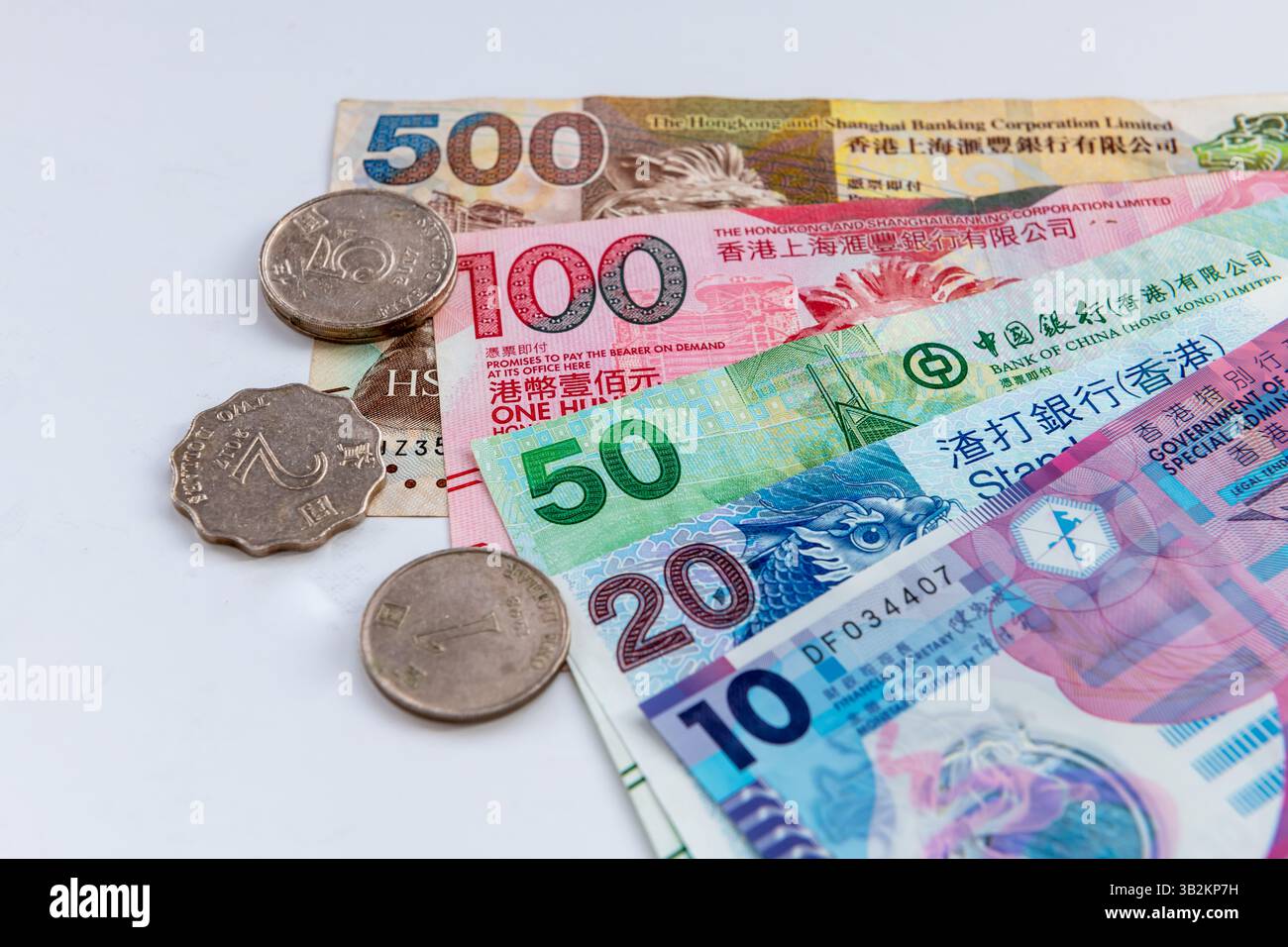 Londres. UK- 04.25.2025. La monnaie physique entière en pièces et billets de banque du dollar de Hong Kong isolé sur blanc. Banque D'Images