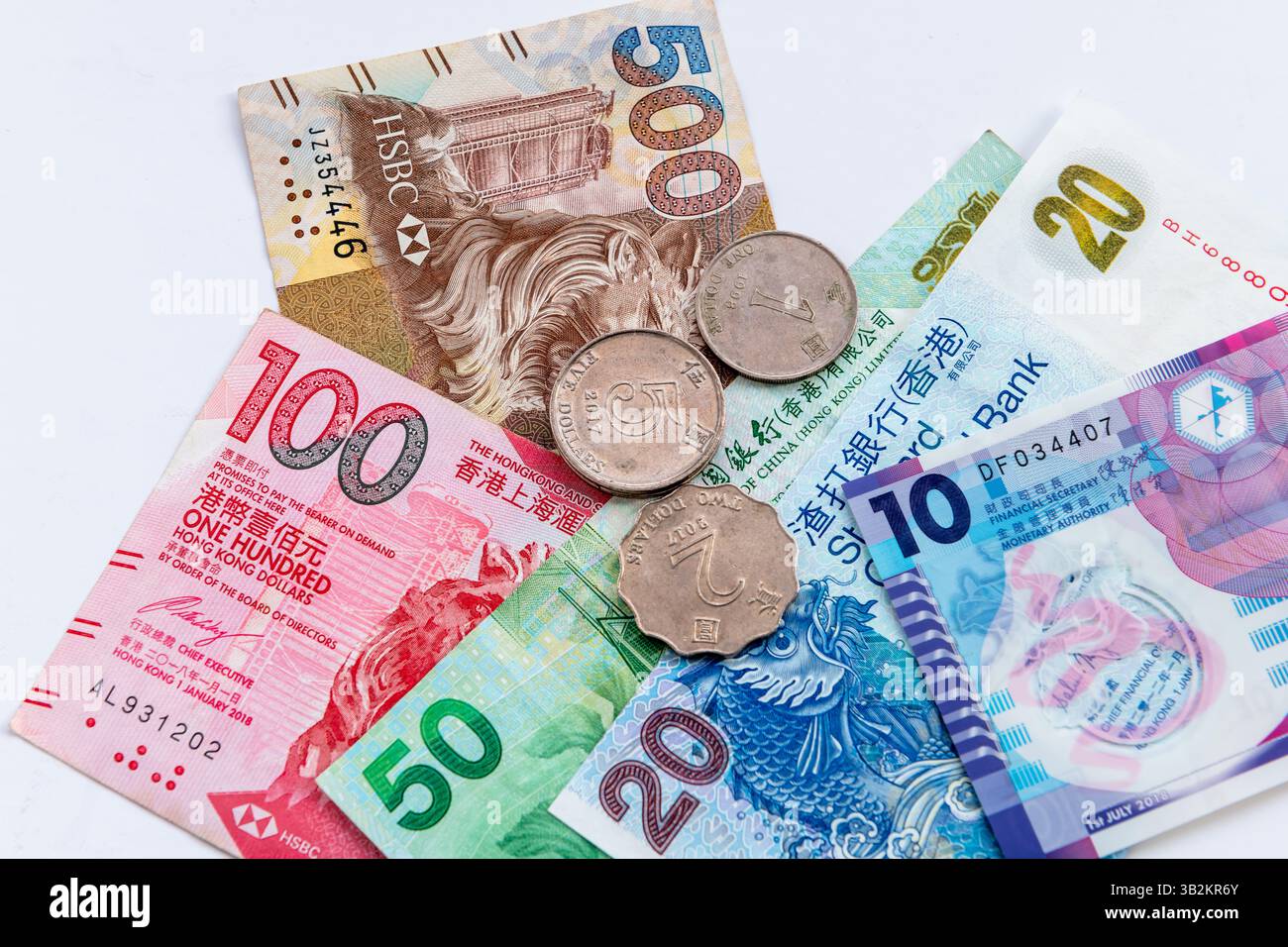 Londres. UK- 04.25.2025. La monnaie physique entière en pièces et billets de banque du dollar de Hong Kong isolé sur blanc. Banque D'Images