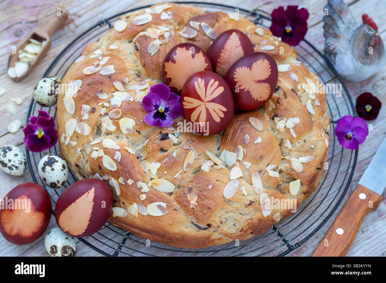arrangement de table de pâques avec oeufs de pâques teints avec motif de feuilles et couronne de levure Banque D'Images