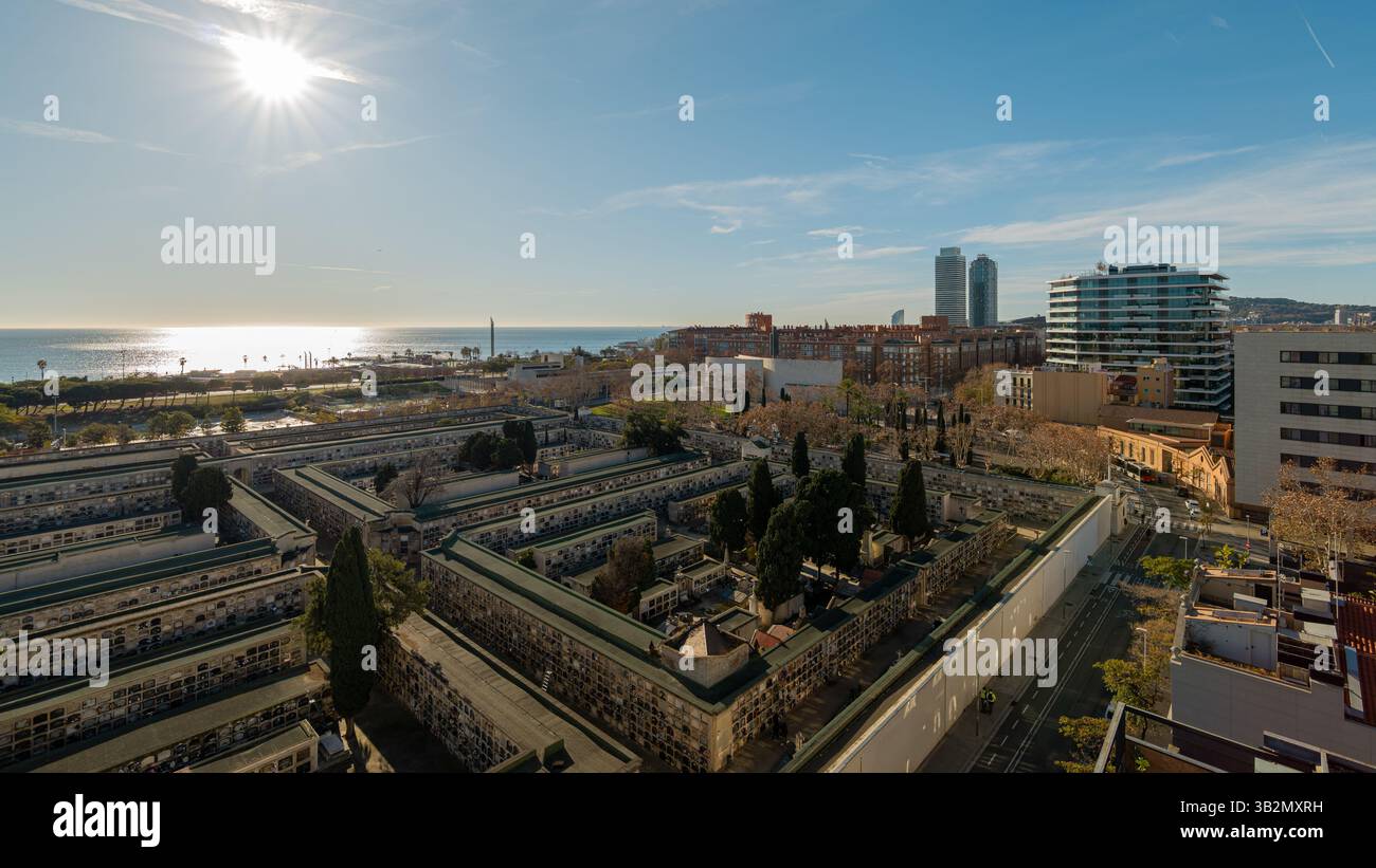 Vue large sur le cimetière historique en bord de mer et l'horizon de Barcelone à distance sous ciel dégagé Banque D'Images