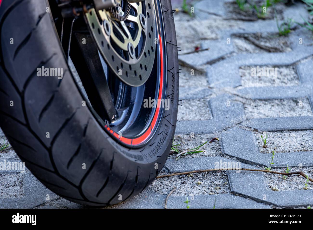 Moto de course rouge, gros plan de pneus de rallye larges Banque D'Images