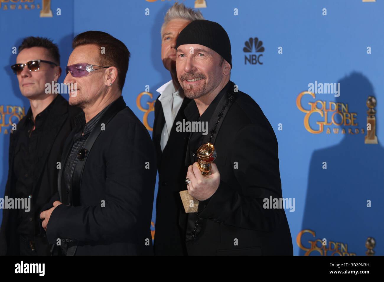 Larry Mullen Jr. (de gauche à droite), Bono et The Edge of U2 posent dans la salle de presse de la 71e édition des Golden Globe Awards alias Golden Globes à l'hôtel Beverly Hilton à Los Angeles, USA, le 12 janvier 2014 Banque D'Images