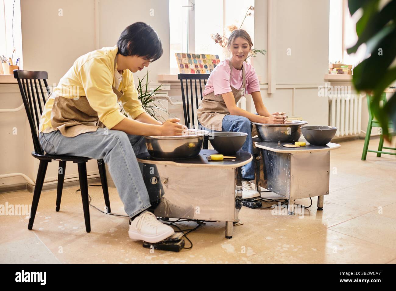 Jeune couple s'engage dans la fabrication de poterie, appréciant les uns les autres compagnie et la créativité artistique. Banque D'Images