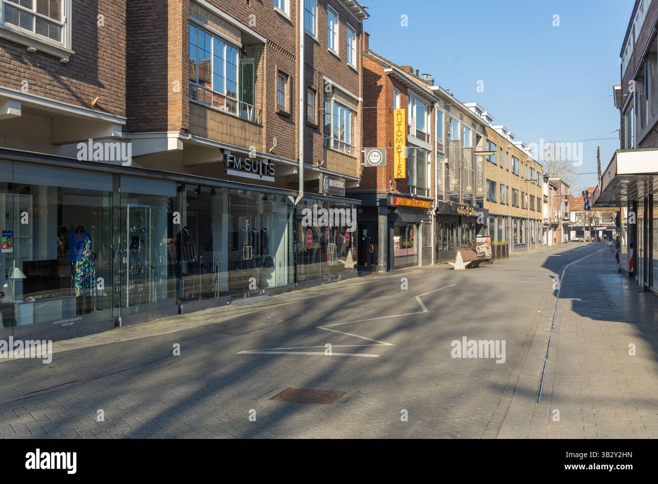 Journée ensoleillée dans une rue commerçante tranquille à Hengelo, aux pays-Bas, avec des magasins de vêtements et une architecture moderne en briques. Hengelo, pays-Bas. 28 ma Banque D'Images