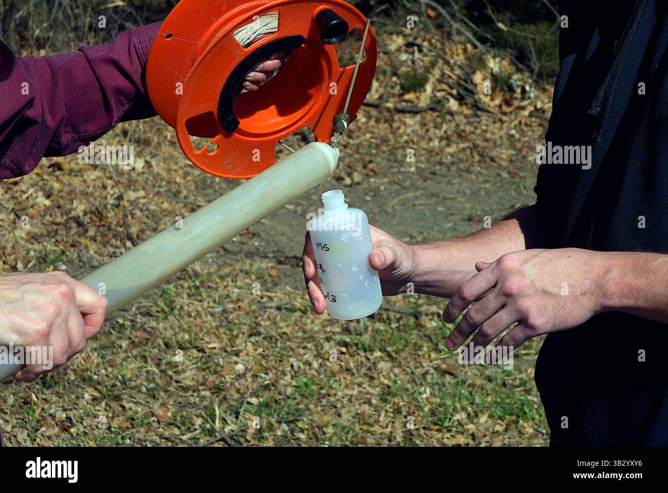 Le 27 mars 2014 - Emporia, Kansas, États-Unis d'Amérique - Emporia, Kansas 3-27-2014.Dr Marcia Schlumeister Professeur agrégé de Sciences physiques et Bryce Waggoner un de ses étudiants utilise un Bailer (un outil qui ramène l'eau des puits pour des échantillons) pour prélever un échantillon d'eau d'un puits d'essai sur le terrain de l'Université d'État Emporia pour tester les niveaux de concentration d'azote et de potassium..crédit : Mark Reinstein (crédit image : © Mark Reinstein via ZUMA Wire) Banque D'Images